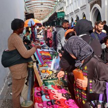 The saleswoman has a baby on her back